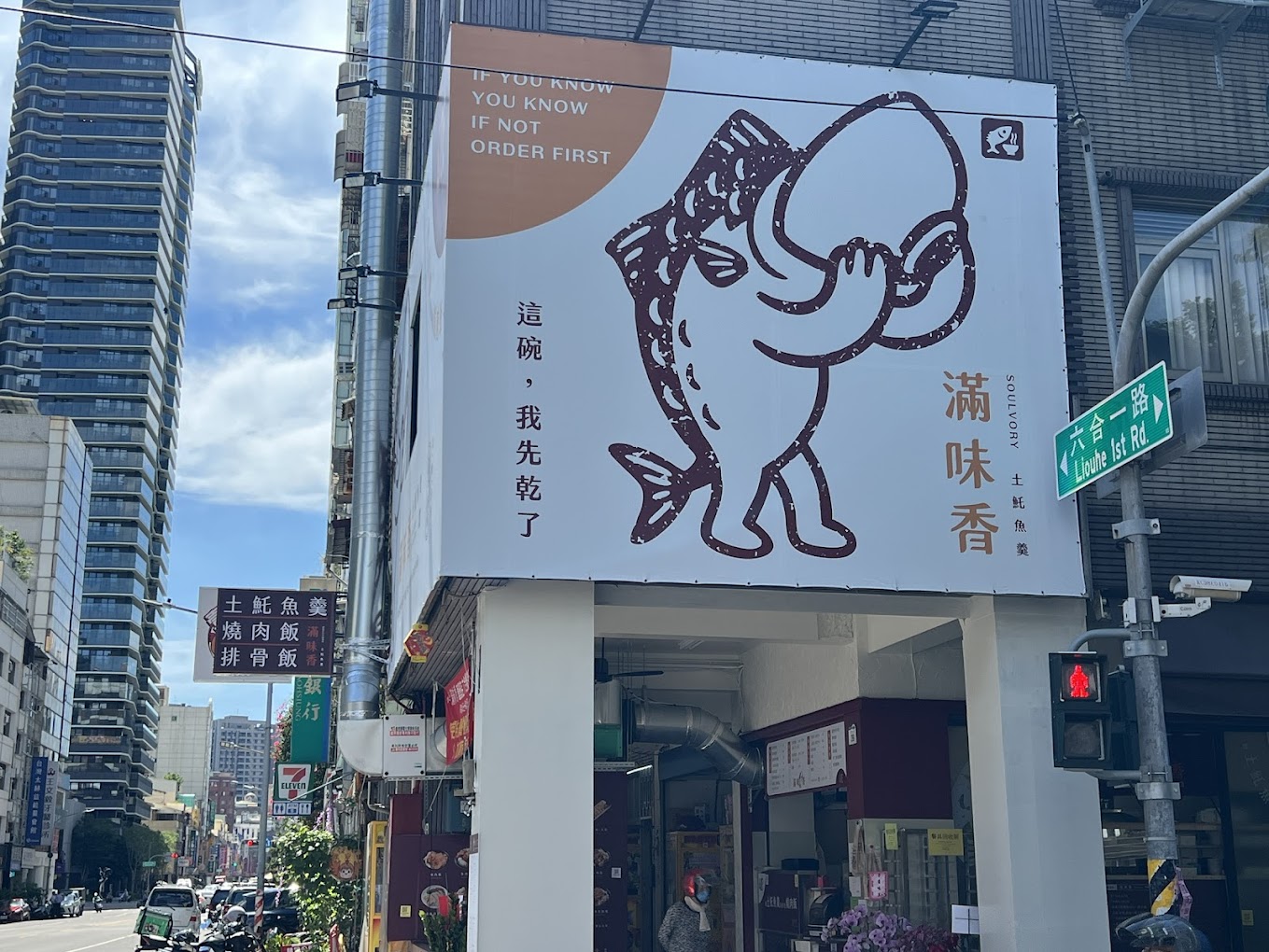 餐飲老店的標誌放大到整面建築外牆，街角看得到大型的魚形圖案與店名